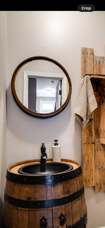 Whiskey barrel vanity sink with hammered copper basin and barrel-hoop mirror