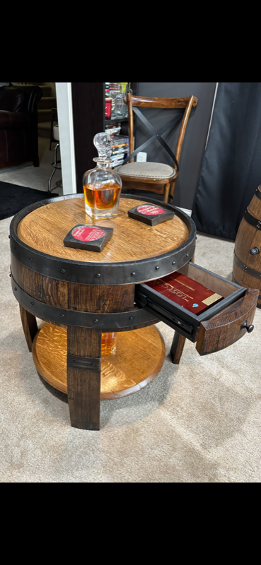 Barrel-head coffee table with pull-out drawer, whiskey decanter, and coasters on top